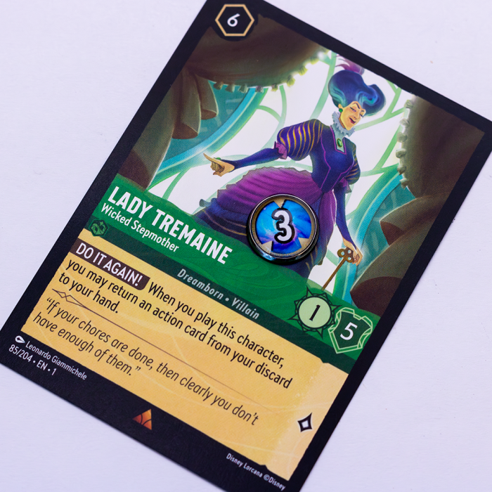 Lorcana Damage 4 Lorcana trading card featuring Lady Tremaine, titled 'Wicked Stepmother'. The card shows her in a regal purple outfit against a green and gold fantasy backdrop. Gameplay stats include Cost 6, Strength 3, Defense 1, and